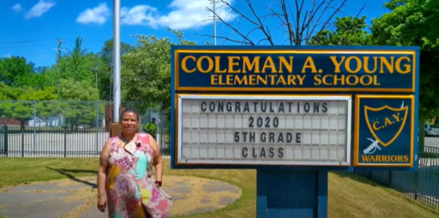  Principal Scott standing next to the school marquee